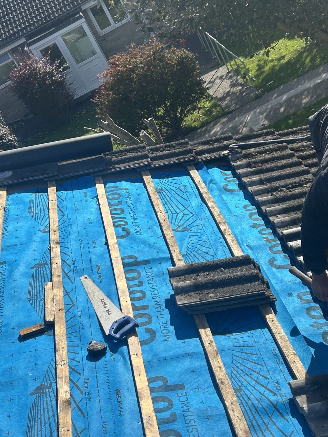 Blue breathable roofing membrane being installed